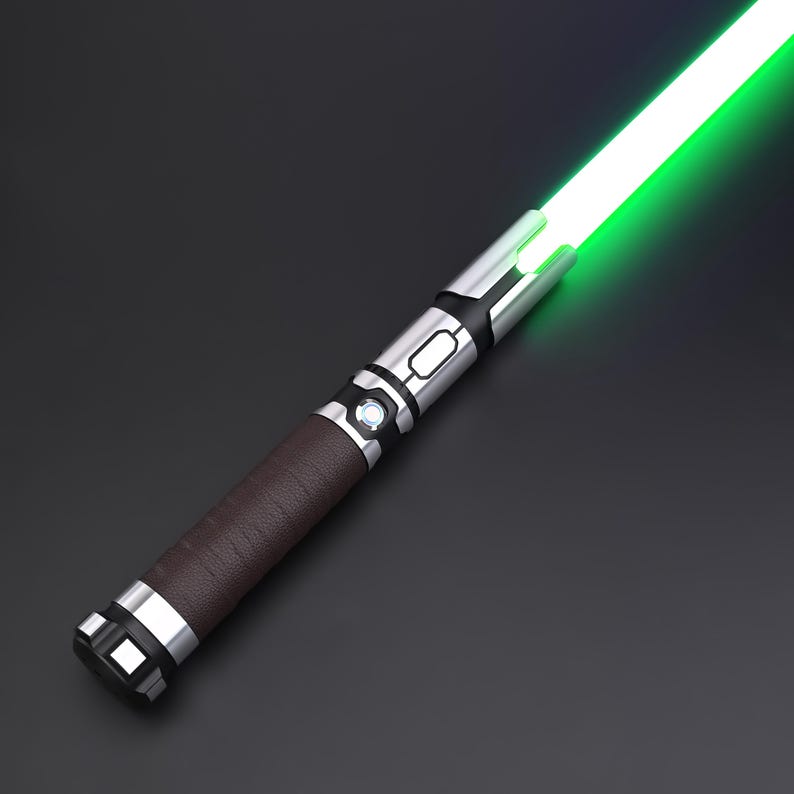 May include: A lightsaber with a green blade and a brown handle. The hilt is silver with black detailing. The handle is wrapped in a textured brown material. The lightsaber has a glowing green blade.