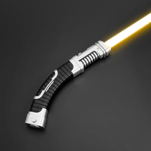 Könnte beinhalten: Ein futuristisches Lichtschwert mit einer leuchtend gelben Klinge. Der Griff ist schwarz und silber, mit einem gebogenen Design und gerippten Details. Das Lichtschwert hat einen Knopf am Ende und ist vor einem dunklen Hintergrund platziert.