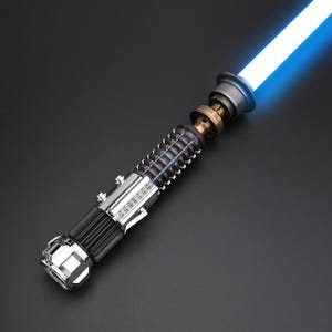 Puede incluir: Un sable de luz detallado con una hoja azul brillante. El mango presenta una combinaci&oacute;n de acabados met&aacute;licos plateados, negros y bronce. El dise&ntilde;o incluye detalles intrincados y una hoja de energ&iacute;a azul brillante.