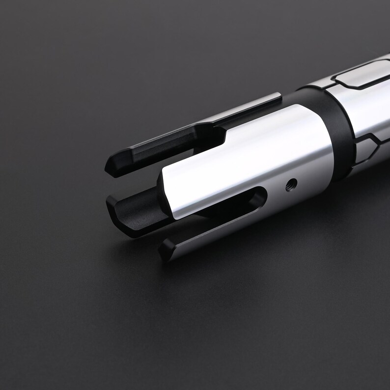 May include: A close-up shot of a silver and black metal tool. It has a cylindrical body and multiple prongs extending from one end. The tool has a polished, reflective surface, suggesting an industrial or mechanical purpose. The background is a solid black.