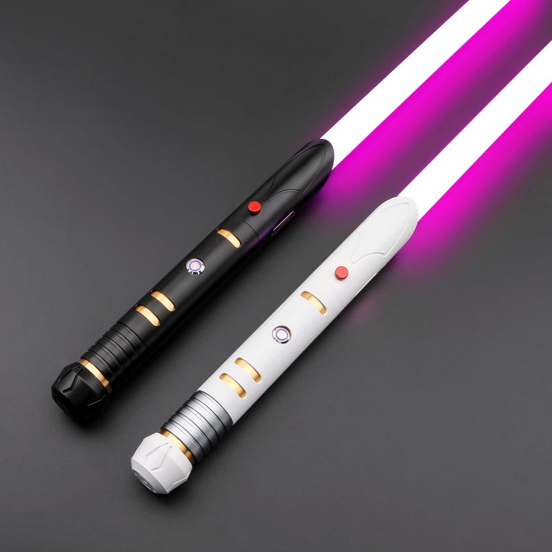 May include: Two lightsabers with glowing purple blades. One is black with gold accents and a red button, the other is white with gold and silver accents and a red button. The hilts have intricate designs.