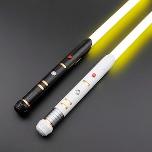 May include: Two illuminated lightsabers with yellow blades. One is black with gold accents and a red button, the other is white with silver and gold accents and a red button. Both have intricate handle designs.