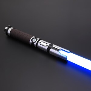 May include: A futuristic lightsaber with a silver and black hilt and a brown handle. The blade emits a bright blue light. The hilt has detailed design elements. The lightsaber is set against a dark background, creating a dramatic contrast.