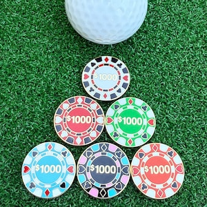 May include: Six colorful poker chips with black and white designs and the text "$1000" on each chip.