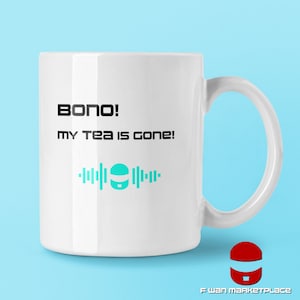 Puede incluir: Taza de cerámica blanca con texto negro que dice "Bono! ¡Mi té se ha ido!" y un gráfico turquesa de un robot con ondas sonoras.