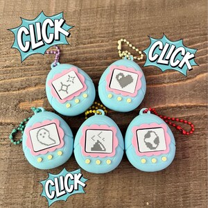 May include: Five light blue retro handheld virtual pet toys with various pixelated icons on the screens. Each toy has a pink border around the screen and yellow buttons. The word "CLICK" is in a speech bubble in the image.