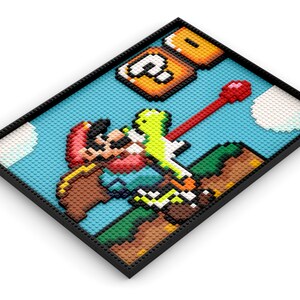 May include: A Lego mosaic art piece depicting a pixelated version of the classic Super Mario Bros. video game. The scene features Mario jumping over a green Koopa Troopa, with a question mark block above. The mosaic is framed in black.