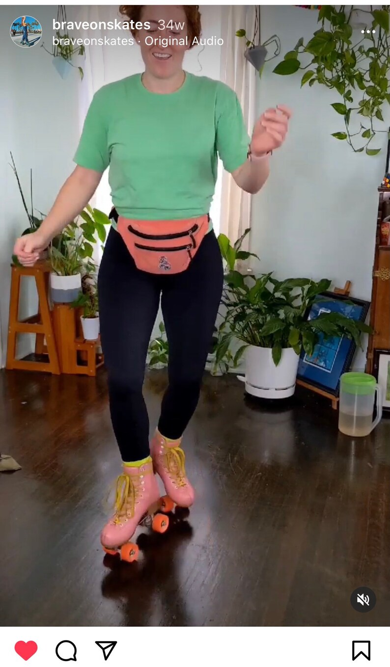 K&ouml;nnte beinhalten: Eine Person tr&auml;gt ein gr&uuml;nes T-Shirt, schwarze Leggings und eine rosa Bauchtasche und rollt auf einem Holzboden Schlittschuh. Die Person tr&auml;gt rosa Rollschuhe mit gelben Schn&uuml;rsenkeln und orangefarbenen Rollen.