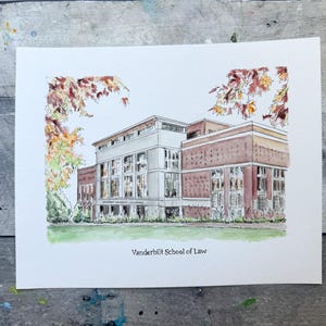 May include: Watercolor painting of the Vanderbilt School of Law building. The building is a light brown brick with white trim and large windows. The painting is framed by fall foliage.