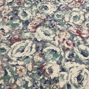 May include: A fabric featuring a dense, painterly floral pattern with large, swirling rose-like blossoms in shades of white, dusty blue, muted teal, and deep burgundy. The design uses thick, visible brushstroke textures throughout the surface.