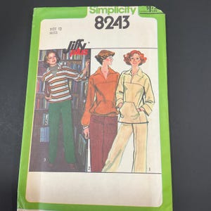 May include: Simplicity 8243 sewing pattern for Misses. The cover features illustrations of three different outfits: a striped top with green pants, an orange top with burgundy pants, and a beige jacket and pants set. The pattern is size 12.