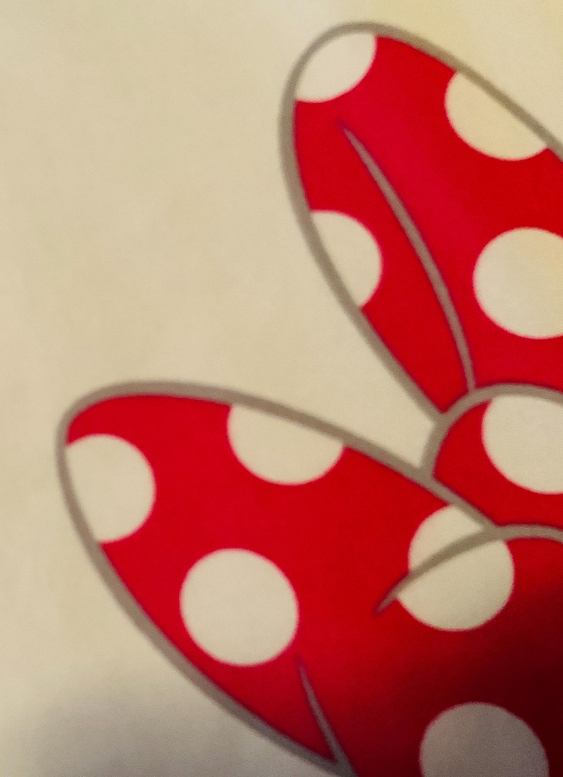 May include: A red bow with white polka dots. The bow is made of a soft, plush fabric.