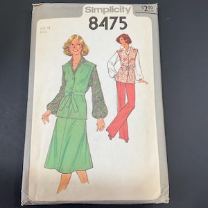 May include: Vintage Simplicity sewing pattern 8475, size 12 Miss. The pattern features illustrations of women's clothing designs, including a green skirt suit with floral sleeves and a belted vest with pants. The package has a price tag.