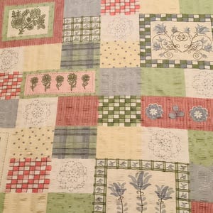 May include: A patchwork fabric with a variety of floral and geometric patterns in shades of green, blue, pink, and red. The fabric has a quilted texture.