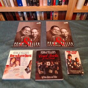 May include: Collection of Penn & Teller memorabilia, including two souvenir booklets, a VHS tape, and two books titled "How to Play in Traffic" and "Cruel Tricks for Dear Friends."