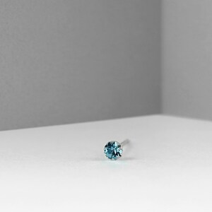 Peut inclure: Un petit anneau de nez en pierre bleue avec une tige argentée.