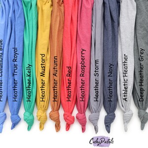 May include: A selection of fabric swatches in various colors, including ice blue, columbia blue, true royal, kelly green, mustard, autumn, red, raspberry, storm, navy, athletic heather, deep heather grey, and dark grey heather. The swatches are arranged in a row from left to right.