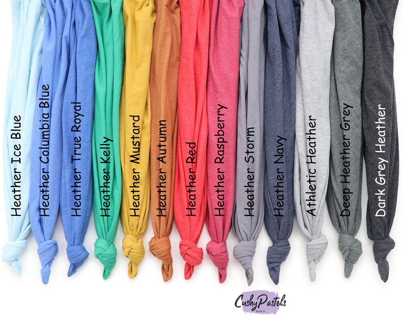 May include: A selection of fabric swatches in various colors, including ice blue, columbia blue, true royal, kelly green, mustard, autumn, red, raspberry, storm, navy, athletic heather, deep heather grey, and dark grey heather. The swatches are arranged in a row from left to right.