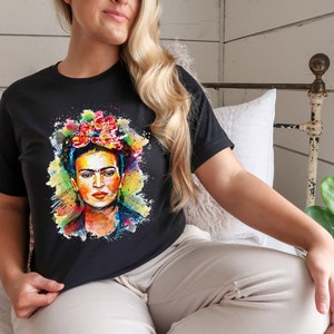 May include: A black t-shirt with a colorful watercolor painting of Frida Kahlo wearing a flower crown.