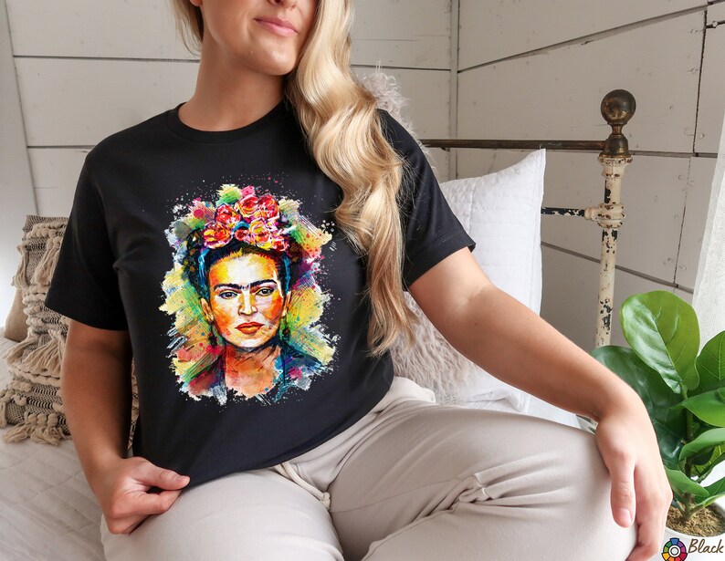 May include: A black t-shirt with a colorful watercolor painting of Frida Kahlo wearing a flower crown.