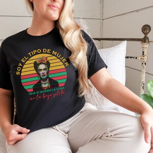 Puede incluir: Camiseta negra con un gr&aacute;fico retro de Frida Kahlo. El gr&aacute;fico presenta una puesta de sol colorida con el texto "Soy el tipo de mujer que si quiero la luna me la bajo solita".