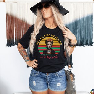 Puede incluir: Camiseta negra con un gr&aacute;fico de estilo vintage de Frida Kahlo. El gr&aacute;fico presenta una puesta de sol roja, amarilla y verde con el texto "Soy el tipo de mujer que si quiero la luna me la bajo solita".