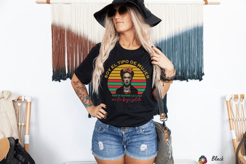 Puede incluir: Camiseta negra con un gr&aacute;fico de estilo vintage de Frida Kahlo. El gr&aacute;fico presenta una puesta de sol roja, amarilla y verde con el texto "Soy el tipo de mujer que si quiero la luna me la bajo solita".