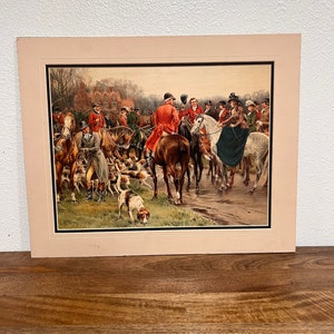 Könnte beinhalten: Ein Vintage-Druck, der eine Jagdszene mit einer Gruppe von Menschen auf Pferden und Hunden zeigt. Die Szene spielt in einem Waldgebiet mit einem Gebäude im Hintergrund. Der Druck ist in einem weißen Passepartout und einem goldenen Rahmen gerahmt.