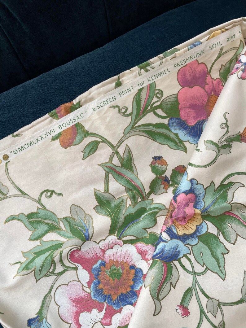 May include: Cream-colored fabric with a large floral pattern in pink, blue, and green. The fabric has a screen print with the text "&copy;MCMLXXXVII BOUSSAC" and "a SCREEN PRINT for KENMILL PRESHRUNK SOIL and S".