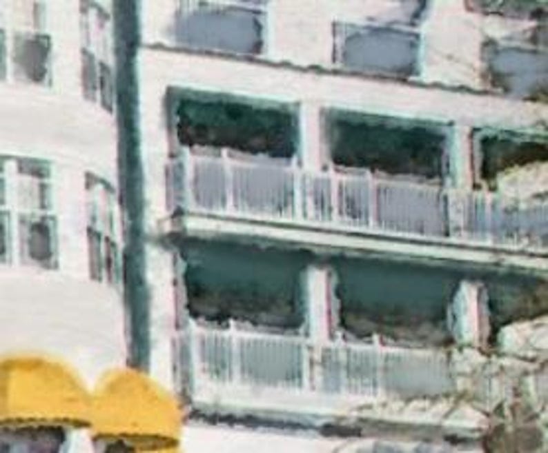 May include: A white building with multiple balconies. The balconies have white railings and are partially obscured by trees.