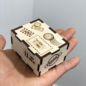 May include: A small wooden box with a brown stain. The box is decorated with a variety of stamps and labels, including "CARGO", "AIR MAIL", "FRAGILE", and "THIS SIDE UP".