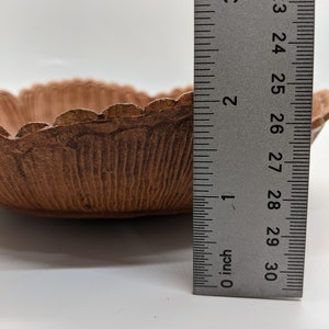 Puede incluir: Un cuenco de cer&aacute;mica marr&oacute;n con un borde festoneado, que mide aproximadamente 18 cm de di&aacute;metro. El cuenco est&aacute; sobre una superficie blanca junto a una regla.