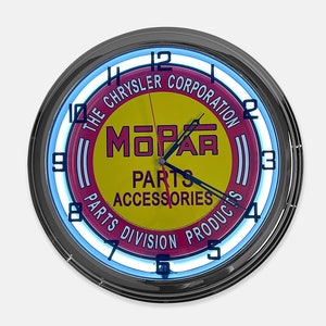 May include: A round, neon clock with a black metal frame. The clock face features the Mopar logo in yellow and red, with the text "The Chrysler Corporation" and "Parts Accessories Parts Division Products". The clock has a blue neon light.