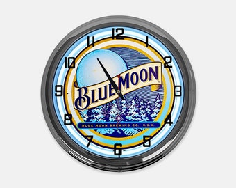 Può includere: Orologio da parete rotondo con cornice nera e logo Blue Moon. Il quadrante presenta un design blu e bianco con le parole "Blue Moon" e "Blue Moon Brewing Co. U.S.A."