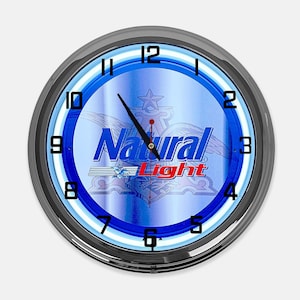 May include: Round wall clock with a blue and white face, featuring the text "Natural Light" in red and blue. The clock has a black bezel and black hands. The clock face has a star and wing design.