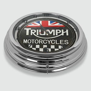 Może przedstawiać: Chromowany zegar Triumph Motorcycles z motywem Union Jack. Tarcza zegara zawiera logo Triumph i napis "Motorcycles". Zegar ma okrągły kształt i łańcuszek.