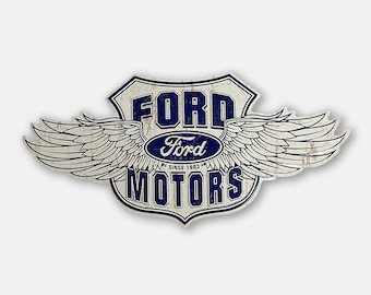 May include: A distressed metal sign featuring the Ford Motors logo with wings. The sign has a blue and white color scheme, with the words "FORD" and "MOTORS" prominently displayed. The sign reads "SINCE 1903".