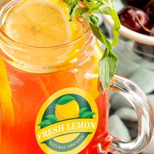 May include: A glass jar filled with a red and orange beverage with a lemon wedge and fresh mint leaves. The jar has a sticker that says "Fresh Lemon Natural Organic".
