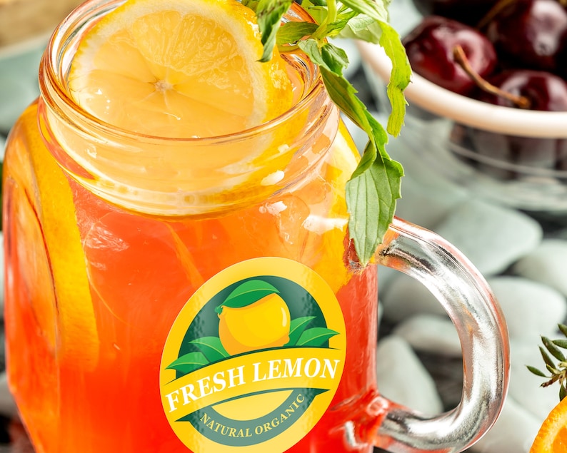May include: A glass jar filled with a red and orange beverage with a lemon wedge and fresh mint leaves. The jar has a sticker that says "Fresh Lemon Natural Organic".