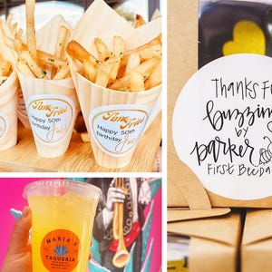 Op de afbeelding: Een assortiment feesteten en -dranken. Houten kegels gevuld met friet met "Time Fries" labels, een doos met gele hartvormige koekjes en een doorzichtige plastic beker met gele vloeistof.