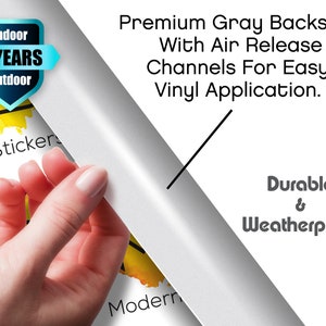 May include: A close-up of a hand peeling back a gray vinyl sticker. The sticker has the text "Premium Gray Backside With Air Release Channels For Easy Vinyl Application." and "Durable & Weatherproof" printed on it. The sticker also has a label that says "Indoor 5 YEARS Outdoor".