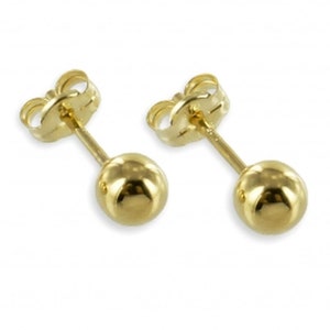 Könnte beinhalten: Ein Paar goldene Ohrstecker mit Kugeln. Die Ohrringe haben ein schlichtes Design und sind perfekt für den Alltag.