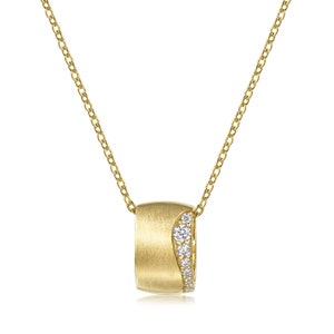 Könnte beinhalten: Eine goldene Halskette mit einem gebürsteten Goldanhänger, der eine geschwungene Linie aus kleinen Diamanten aufweist.