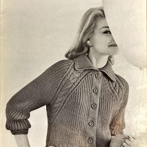 Peut inclure: Un cardigan marron boutonné de style vintage. Le pull présente des détails en tricot torsadé sur les manches et les panneaux avant, avec un col et des poignets côtelés. Le vêtement fait partie d'un thème de mode rétro.