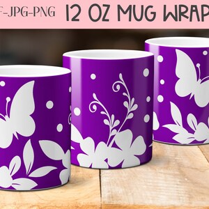 K&ouml;nnte beinhalten: Drei wei&szlig;e Keramikbecher mit 12 Unzen Fassungsverm&ouml;gen, mit violettem Hintergrund und wei&szlig;en Blumen- und Schmetterlingsmotiven. Die Becher stehen auf einer Holzoberfl&auml;che.