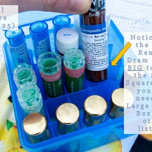 May include: A blue plastic square box with a grid of compartments, holding various small glass bottles and vials. The text "Small Square (Holds 25)" is visible on the box. A larger bottle labeled "Homeopathic Medicine" is being placed in the box, but it is too big to fit. The text "Notice how the WHP Remedy Dram is TOO BIG to fit in the Small Square Box - you will need the Large Square Box (see other listing)" is visible.