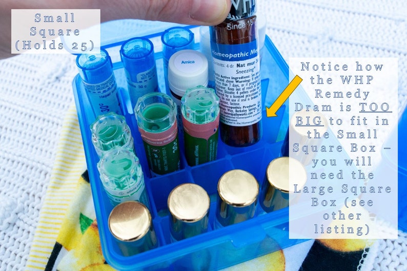 May include: A blue plastic square box with a grid of compartments, holding various small glass bottles and vials. The text "Small Square (Holds 25)" is visible on the box. A larger bottle labeled "Homeopathic Medicine" is being placed in the box, but it is too big to fit. The text "Notice how the WHP Remedy Dram is TOO BIG to fit in the Small Square Box - you will need the Large Square Box (see other listing)" is visible.