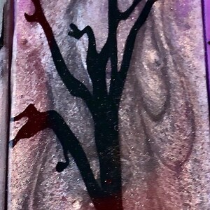 May include: A purple and silver background with a black silhouette of a tree and a crow. The background has a glittery texture.