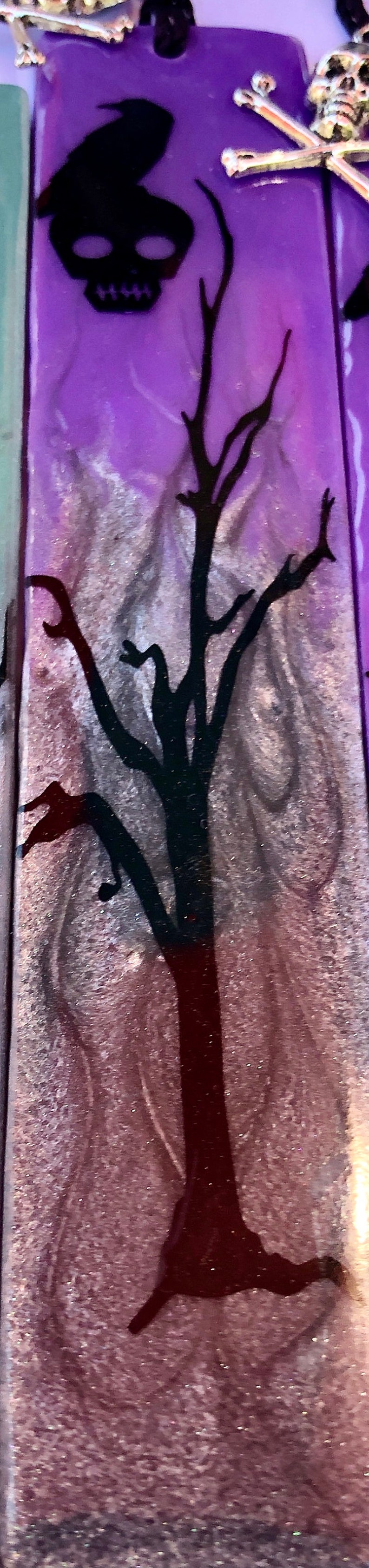 May include: A purple and silver background with a black silhouette of a tree and a crow. The background has a glittery texture.