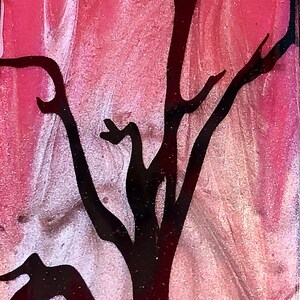 May include: A black crow with a skull head sits above a black silhouette of a bare tree on a pink and white background.
